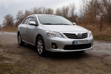 Dnipro, Ukrayna - 25 Ocak 2021: Toyota Corolla 2011, gümüş rengi, yağmurda araba