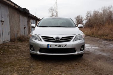 Dnipro, Ukrayna - 25 Ocak 2021: Toyota Corolla 2011, gümüş rengi, yağmurda araba