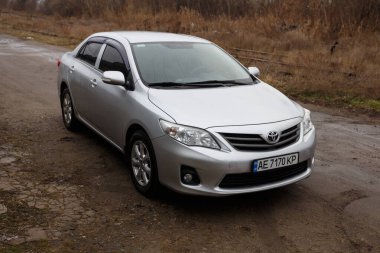 Dnipro, Ukrayna - 25 Ocak 2021: Toyota Corolla 2011, gümüş rengi, yağmurda araba