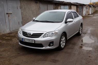 Dnipro, Ukrayna - 25 Ocak 2021: Toyota Corolla 2011, gümüş rengi, yağmurda araba
