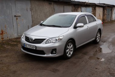 Dnipro, Ukrayna - 25 Ocak 2021: Toyota Corolla 2011, gümüş rengi, yağmurda araba