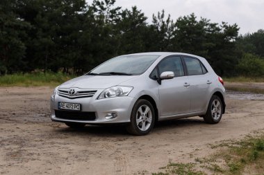 Dnipro, Ukrayna - 30 Temmuz 2021: Toyota Auris 2012 Orman yakınlarındaki şehirde gümüş rengi. Yaz yağmuru