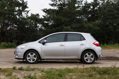 Dnipro, Ukrayna - 30 Temmuz 2021: Toyota Auris 2012 Orman yakınlarındaki şehirde gümüş rengi. Yaz yağmuru