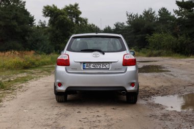 Dnipro, Ukrayna - 30 Temmuz 2021: Toyota Auris 2012 Orman yakınlarındaki şehirde gümüş rengi. Yaz yağmuru
