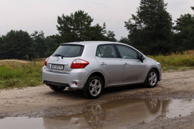 Dnipro, Ukrayna - 30 Temmuz 2021: Toyota Auris 2012 Orman yakınlarındaki şehirde gümüş rengi. Yaz yağmuru