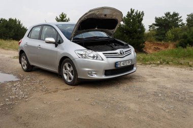 Dnipro, Ukrayna - 30 Temmuz 2021: Toyota Auris 2012 açık kapüşonlu gümüş rengi. Yaz yağmuru