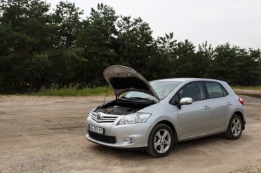 Dnipro, Ukrayna - 30 Temmuz 2021: Toyota Auris 2012 açık kapüşonlu gümüş rengi. Yaz yağmuru
