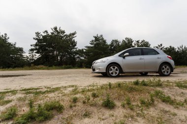 Dnipro, Ukrayna - 30 Temmuz 2021: Toyota Auris 2012 Orman yakınlarındaki şehirde gümüş rengi. Yaz yağmuru