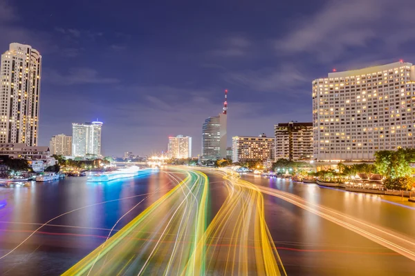 Moving ship with blur light through city at night — Stock Photo, Image