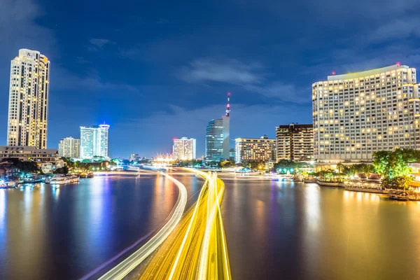 Moving ship with blur light through city at night — Stock Photo, Image