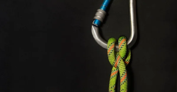 Dikey Karabinalı kayıkçı düğümü ve floresan yeşil ipli siyah arka plan