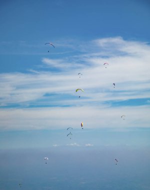 Group of paragliders in flight with background in blue sky
