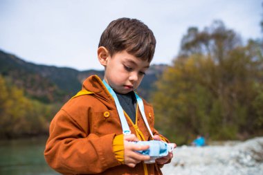 Bir çocuğun yatay portresi, melez bir Brezilyalı ve Japonca soğuk hava fotoğraflarına bakıyor. Bu bir turist gezisi..