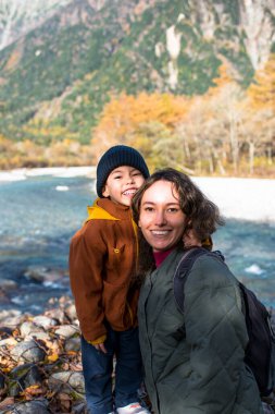 Oğlu, sonbahar mevsiminde, güzel bir arazide, nehirler ve dağlarla birlikte annesine, gezginlerine sarılıyordu.