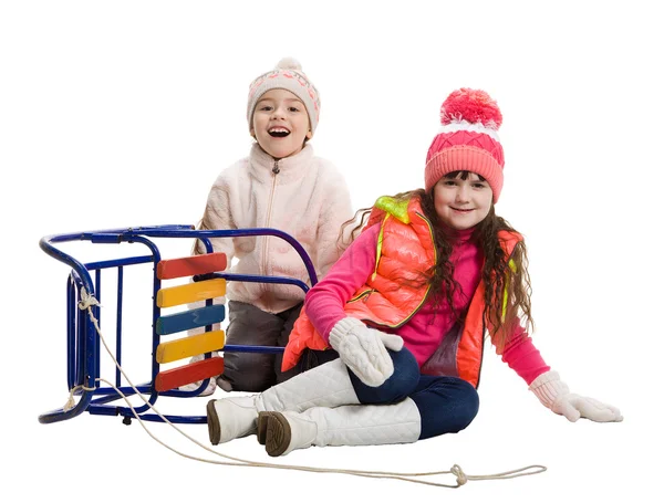 Two happy girls in winter clothes beside sled — Stock Photo, Image