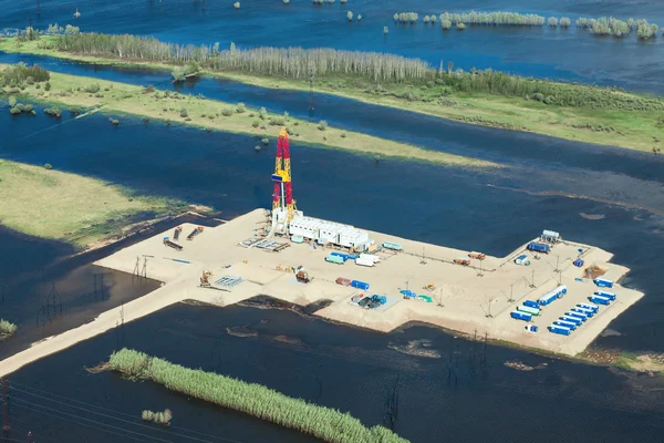 Oil rig in flooded area near great river, top view — Stock Photo, Image