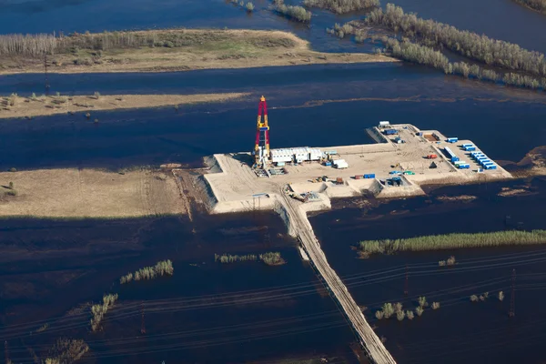 Oil rig in flooded area near great river, top view — Stock Photo, Image