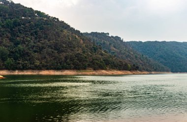 lake calm water with mountain background at day from flat angle image is taken at umiam lake shillong meghalaya india.