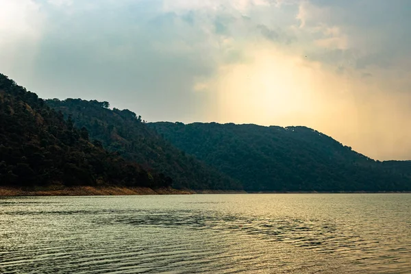 lake calm water with mountain background at day from flat angle image is taken at umiam lake shillong meghalaya india.