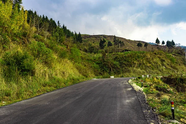 asphalt tarmac isolated road with grass and cloudy sky at morning