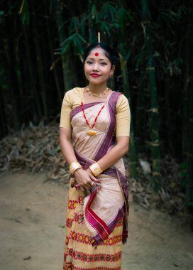 Festivalde geleneksel giyinmiş, arka planda bulanık görüntüsü olan gülen kız yüzü Assam Hindistan 'da bihu vesilesiyle çekiliyor..