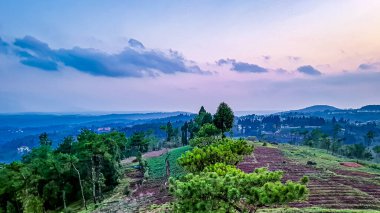Gün batımı dramatik gökyüzü dağlar ve ormanlar alacakaranlıkta düz açıyla.