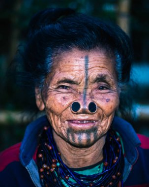 Apatani kabilesindeki kadınların yüz ifadeleri, geleneksel burun lobları ve bulanık arkaplan görüntüleriyle Ziro Arunachal Pradesh Hindistan 'da çekilmiştir. Hindistan 'ın en eski kabilesinden biri..