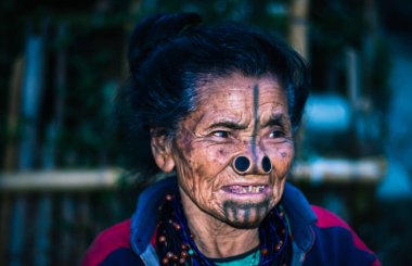 Apatani kabilesindeki kadınların yüz ifadeleri, geleneksel burun lobları ve bulanık arkaplan görüntüleriyle Ziro Arunachal Pradesh Hindistan 'da çekilmiştir. Hindistan 'ın en eski kabilesinden biri..
