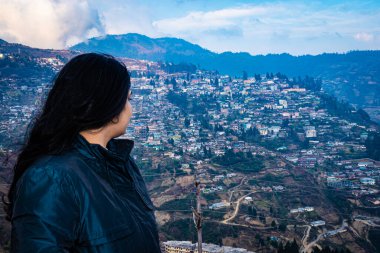Kalabalık şehir yapısı ve muhteşem gökyüzü ile izole edilmiş kız Bombdial Arunachal Pradesh Hindistan 'da çekiliyor..