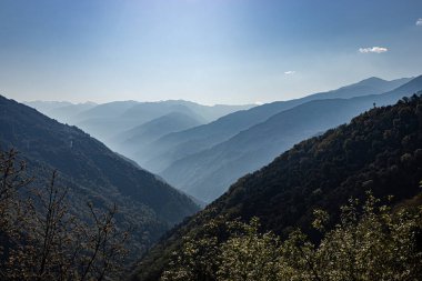 Dağ vadisi sabah beyaz sisle kaplıdır.