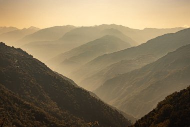 Dağ vadisi sabah beyaz sisle kaplıdır.