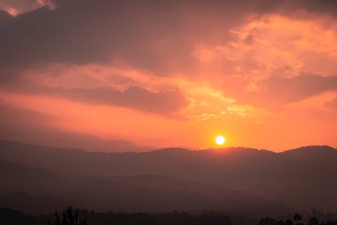 Şafak vakti, Ziro Arunachal Pradesh Hindistan 'da, turuncu dramatik gökyüzü ile dağların üzerinde gün doğumu görüntüsü alınır..