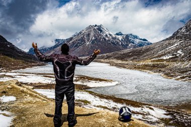 Dağın tepesinde izole edilmiş genç bir adam. Gündüz gökyüzü dramatik. Resim, Tawang Arunachal Pradesh Hindistan 'da çekildi..