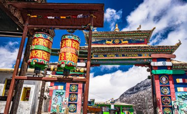 Dini tekerler ve parlak mavi gökyüzü ile şehrin sanatsal Budist dekore edilmiş giriş kapısı sabah resmi ile çekilir sela pass tawang arunachal pradesh India. O, en yüksek geçitlerden biridir..
