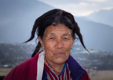 Monpa kabilesinin geleneksel elbise portreleri içinde yaşlı bir kadın detaylarla kapanıyor.