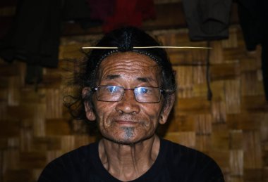 Apatani kabilesinin yüz ifadesi geleneksel saç stili ve bulanık arkaplan görüntüsüyle Ziro Arunachal Pradesh Hindistan 'da çekilmiştir. Hindistan 'ın en eski kabilesinden biri..