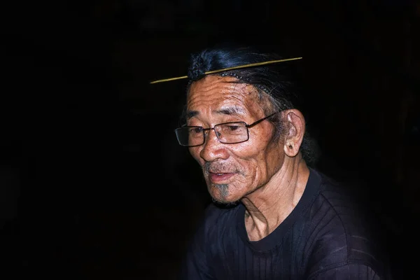 apatani tribal men facial expression with his traditional hair style and black background image is taken at ziro arunachal pradesh india. it is one of the oldest tribe of india.