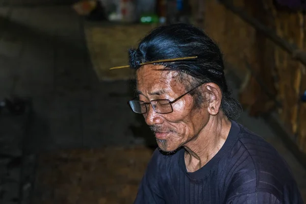 apatani tribal men facial expression with his traditional hair style and blurred background image is taken at ziro arunachal pradesh india. it is one of the oldest tribe of india.