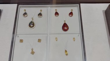 Zarif gözyaşı kolyesi ve takı vitrininde sergilenen küpeler.