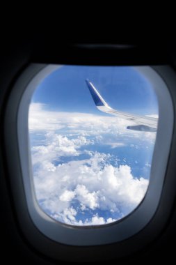 Pencereden görünen mavi gökyüzü ufkunun üstündeki kanat