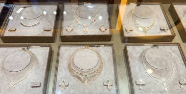 Kadife tepsilerde sergilenen elmas kolye ve küpe setleri