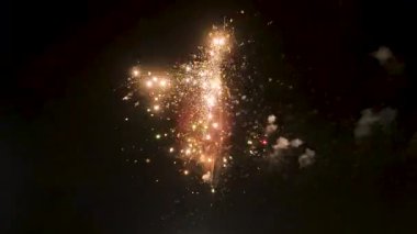 Gece gökyüzünde altın kıvılcımlar saçan havai fişekler