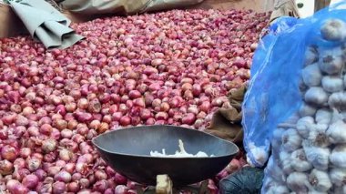 Sebze pazarında yığılmış taze kırmızı soğanlar.