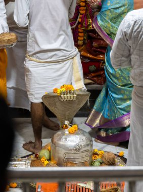 Hindu tanrısı Şiva tapınağında sunulan çiçeklerle bezenmiş gümüş kaplamalı kutsal bıçak.