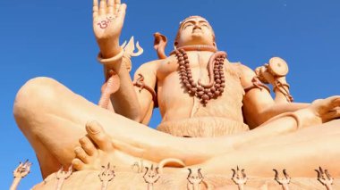 Güneşli gökyüzü altında düşük açılı geleneksel özelliklere sahip dingin şiva idolü