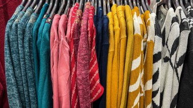 Moda dükkanında asılı çeşitli renklerde kalın örülü kazaklar.