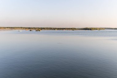 Sakin nehir suyu ve parlak günbatımı gökyüzü akşam