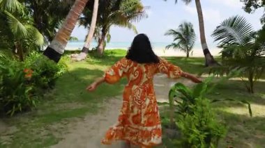 Tropik, el değmemiş okyanus manzarasının tadını çıkaran bir kadınla rahat bir tatil ortamı.