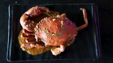 Siyah tabakta servis edilen baharatlı köri.