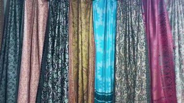 Yerel pazarda asılı geleneksel Hint giyim tekstil ürünleri